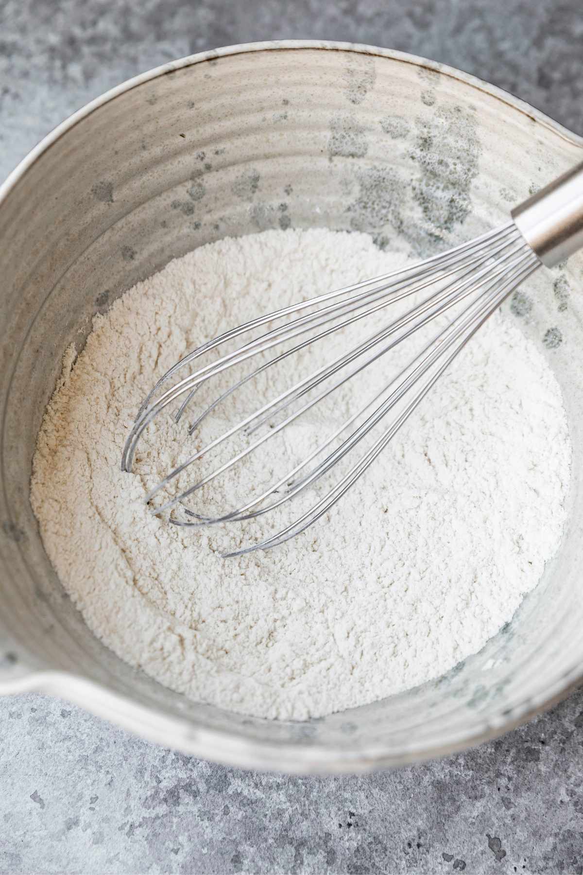 Whisking flour and baking powder together in a large bowl.