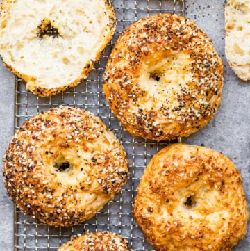 Baked protein bagels with cottage cheese on a cooling rack.