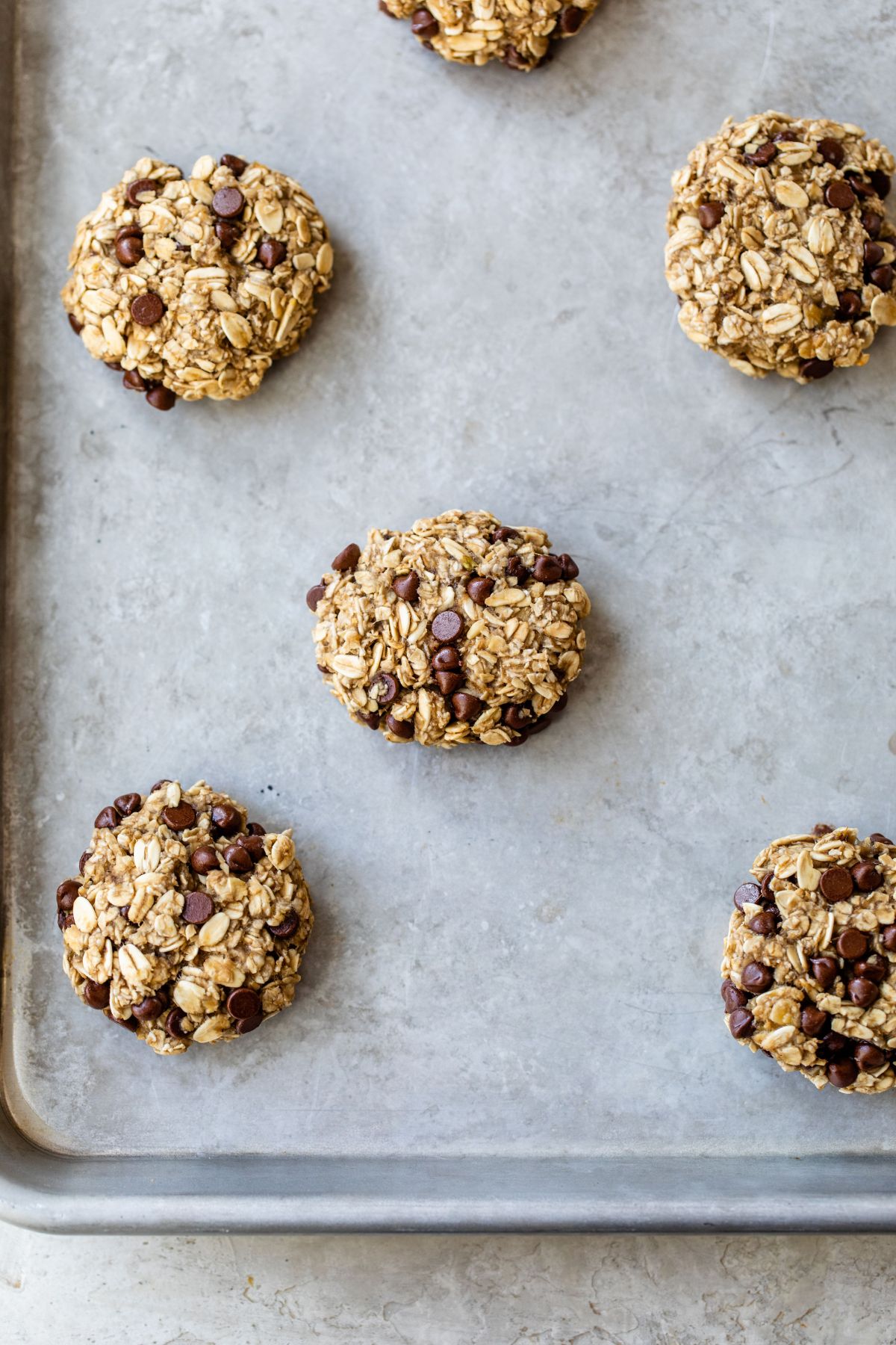 Oatmeal chocolate chip cookies on a baking pan.
