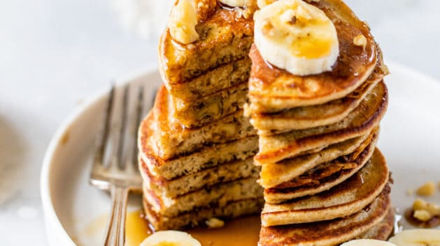 banana oatmeal pancakes cut into and topped with bananas