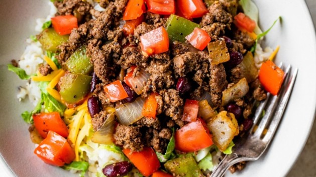 Bison taco bowl served in a white bowl with a fork.