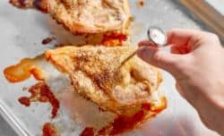 checking the temperature of chicken breast with a thermometer