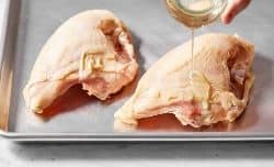 drizzling avocado oil over chicken breasts