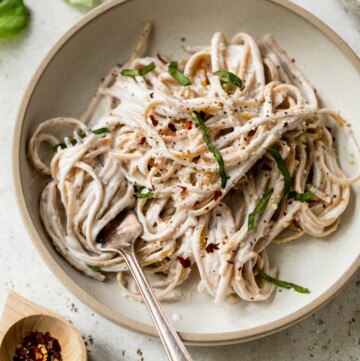 Alfredo made with cottage cheese served over whole grain linguine on a plate with a fork.