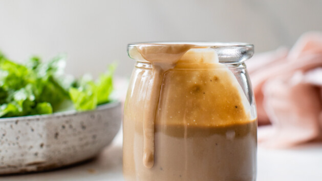 creamy balsamic dressing in a glass jar with salad greens