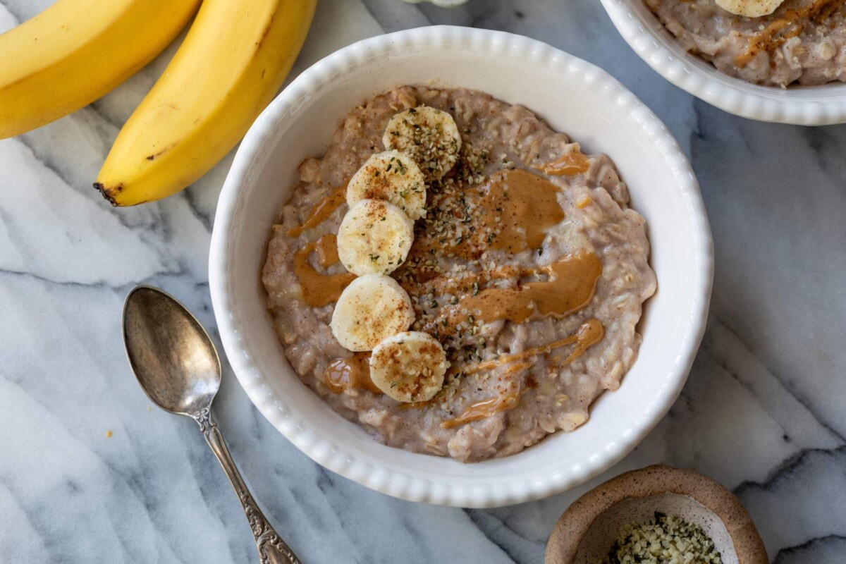 Oatmeal in a bowl with banana slices, chia seeds and a drizzle of almond butter.