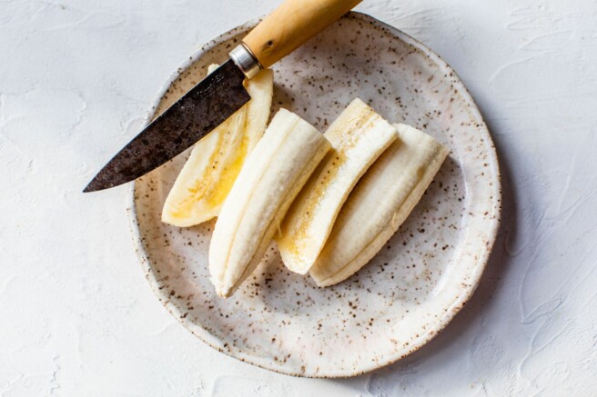 Bananas sliced horizontally on a plate.