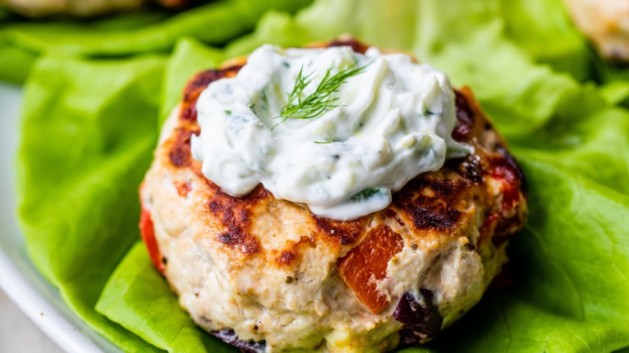 Greek Turkey Burgers served on lettuce and topped with Tzatziki sauce.
