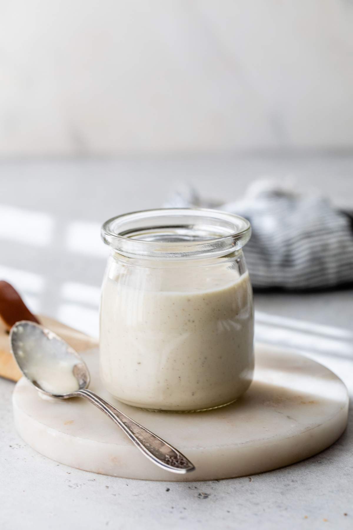 Greek yogurt caesar dressing in a small glass jar.