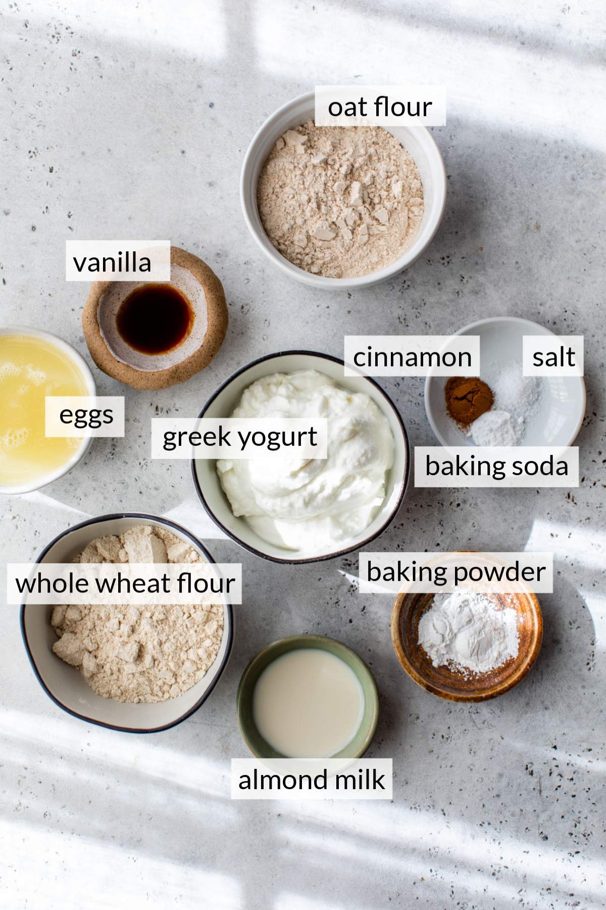 Bowls with flour, Greek yogurt, milk and eggs.