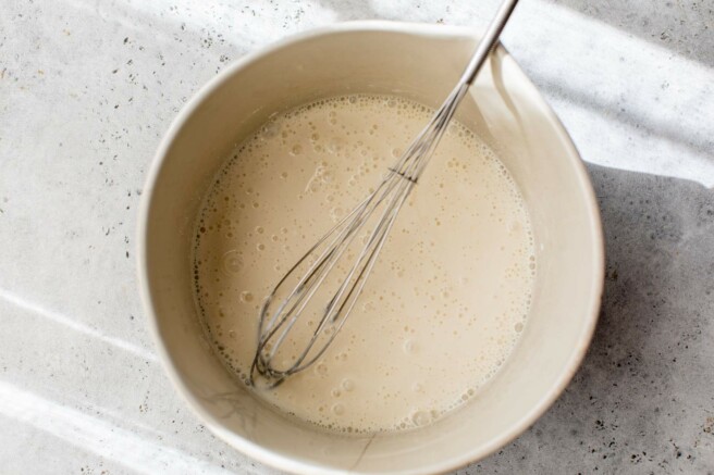 Whisking eggs with almond milk, Greek yogurt and vanilla.