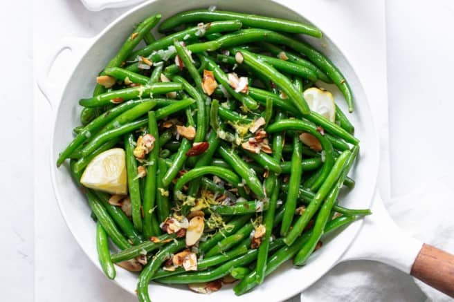 green bean almandine in a large white skillet