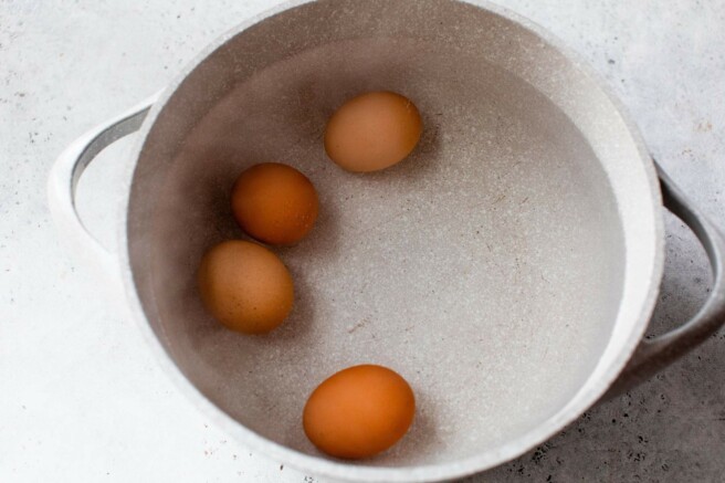 Eggs boiling in a pot.