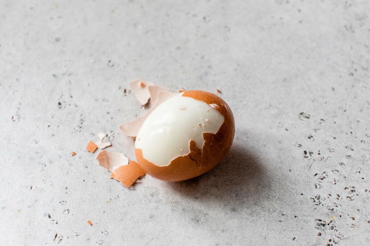 Partially peeled boiled egg.