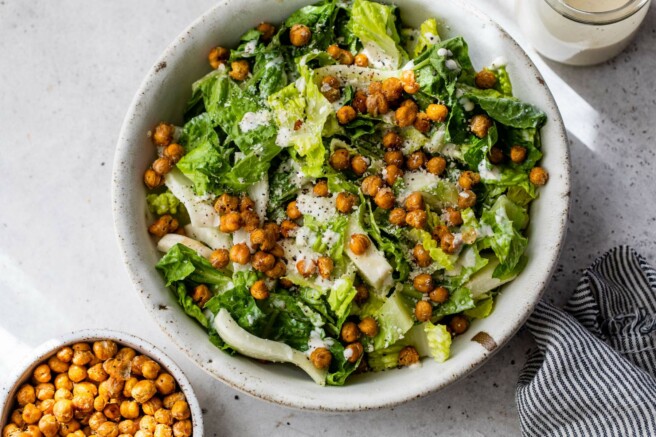 Roasted chickpeas served over romaine lettuce in a salad bowl.