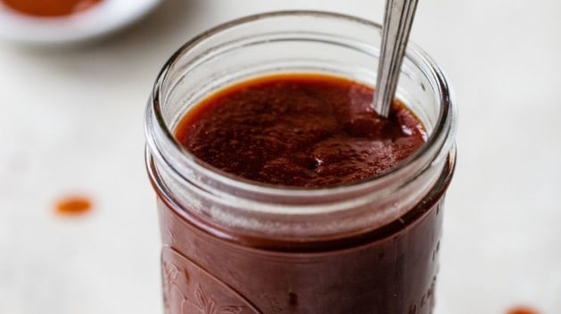 Homemade BBQ sauce in a small mason jar.