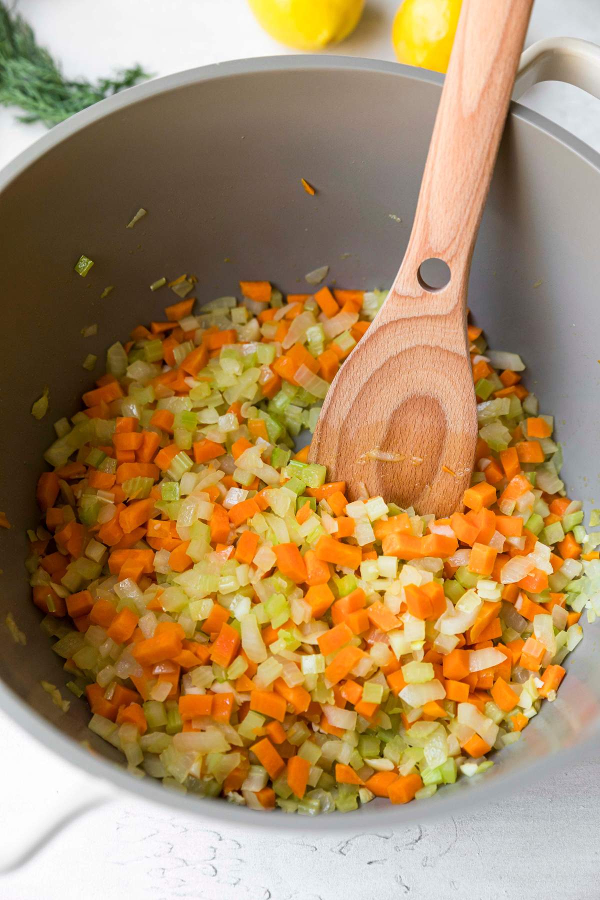 Sautéing carrots, onion and celery in a large pot.