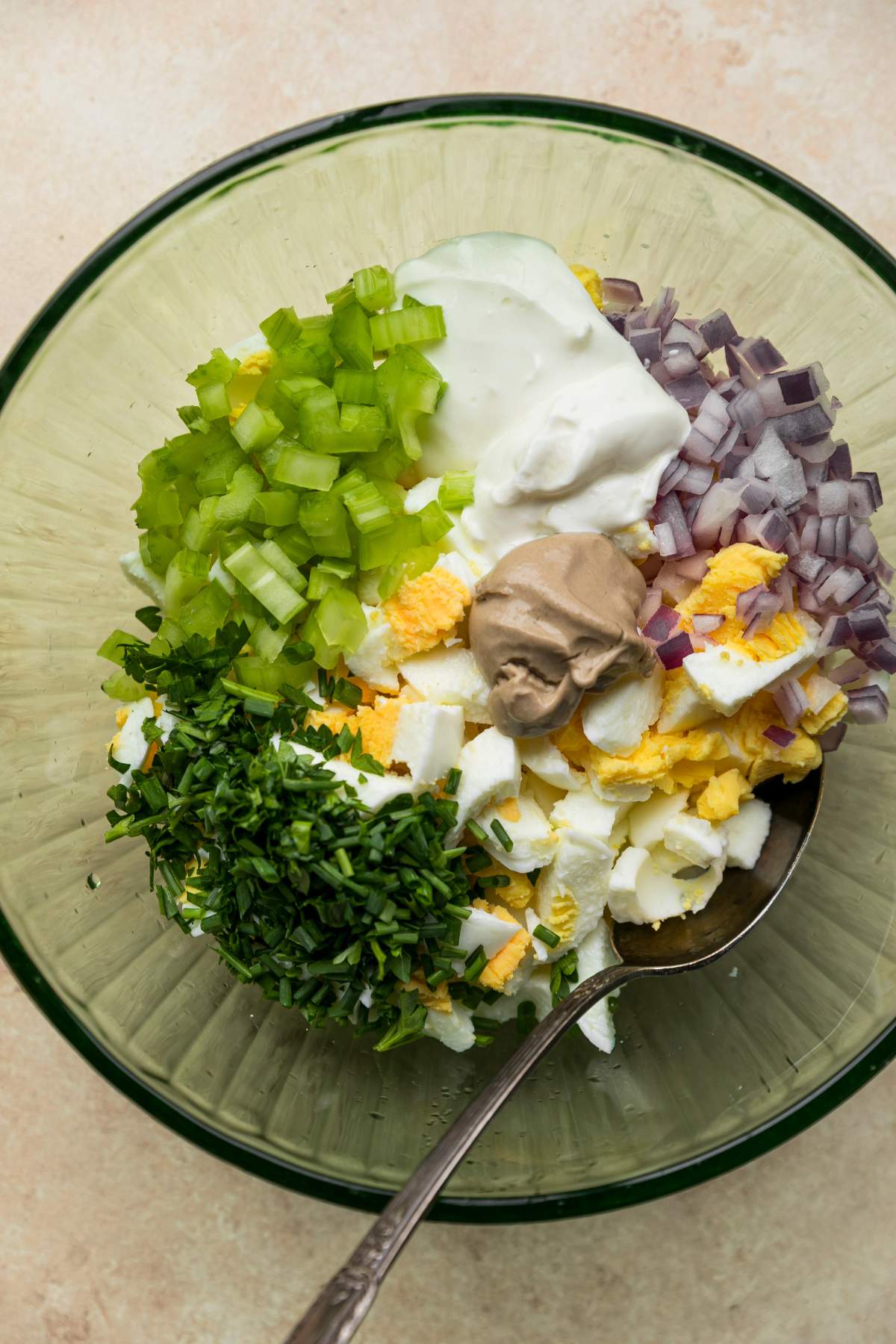 Chopped egg in a bowl with diced veggies, herbs and Greek yogurt.