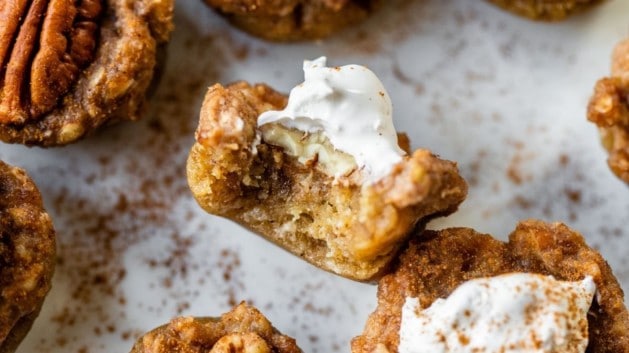 mini pecan pies on a plate with a bite taken out of one