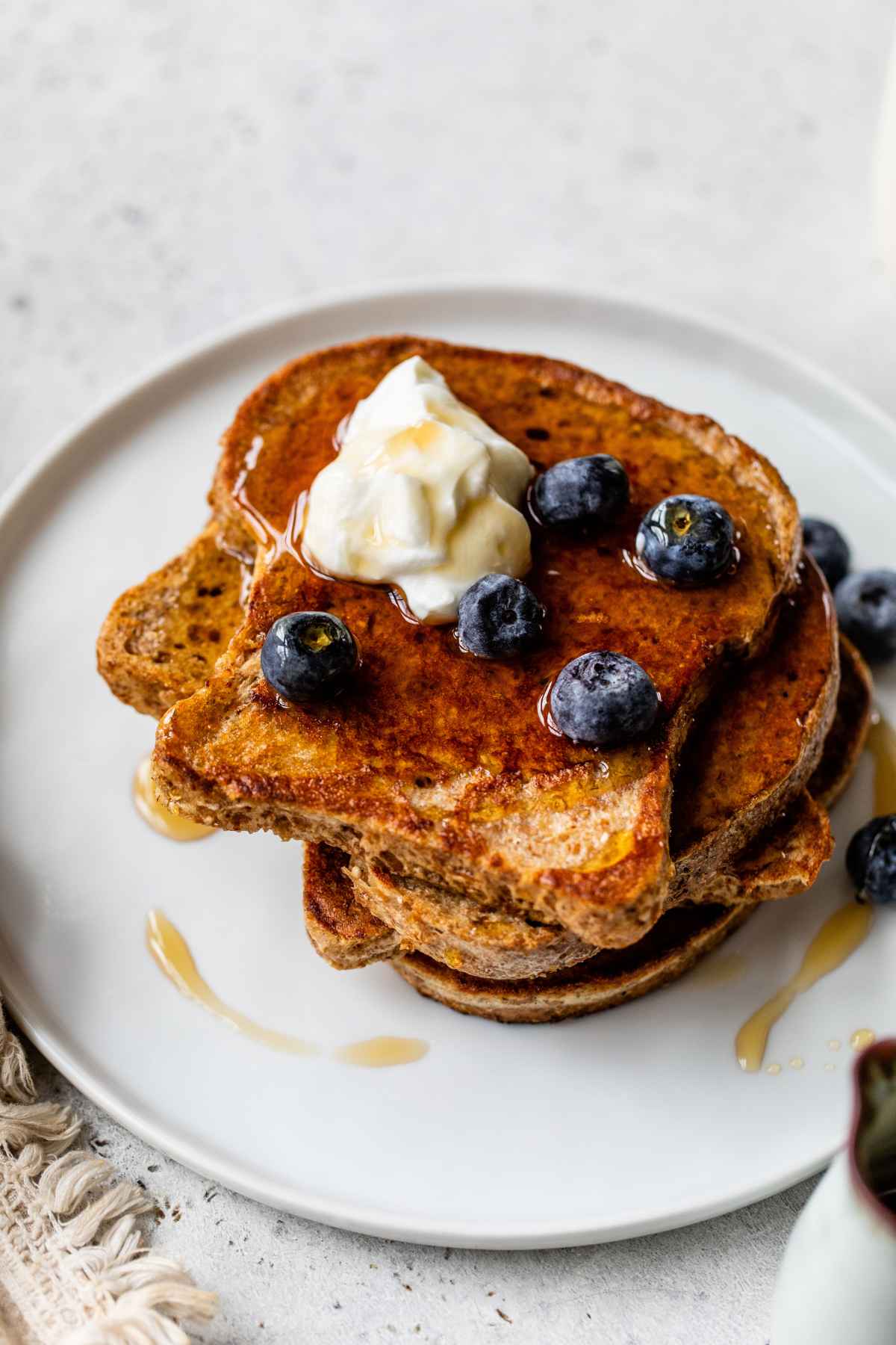 Protein French toast stacked on a white plate.