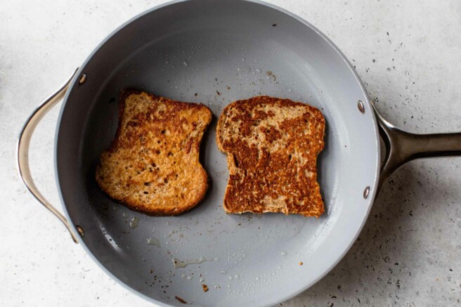 French toast bread slices cooking in a skillet.