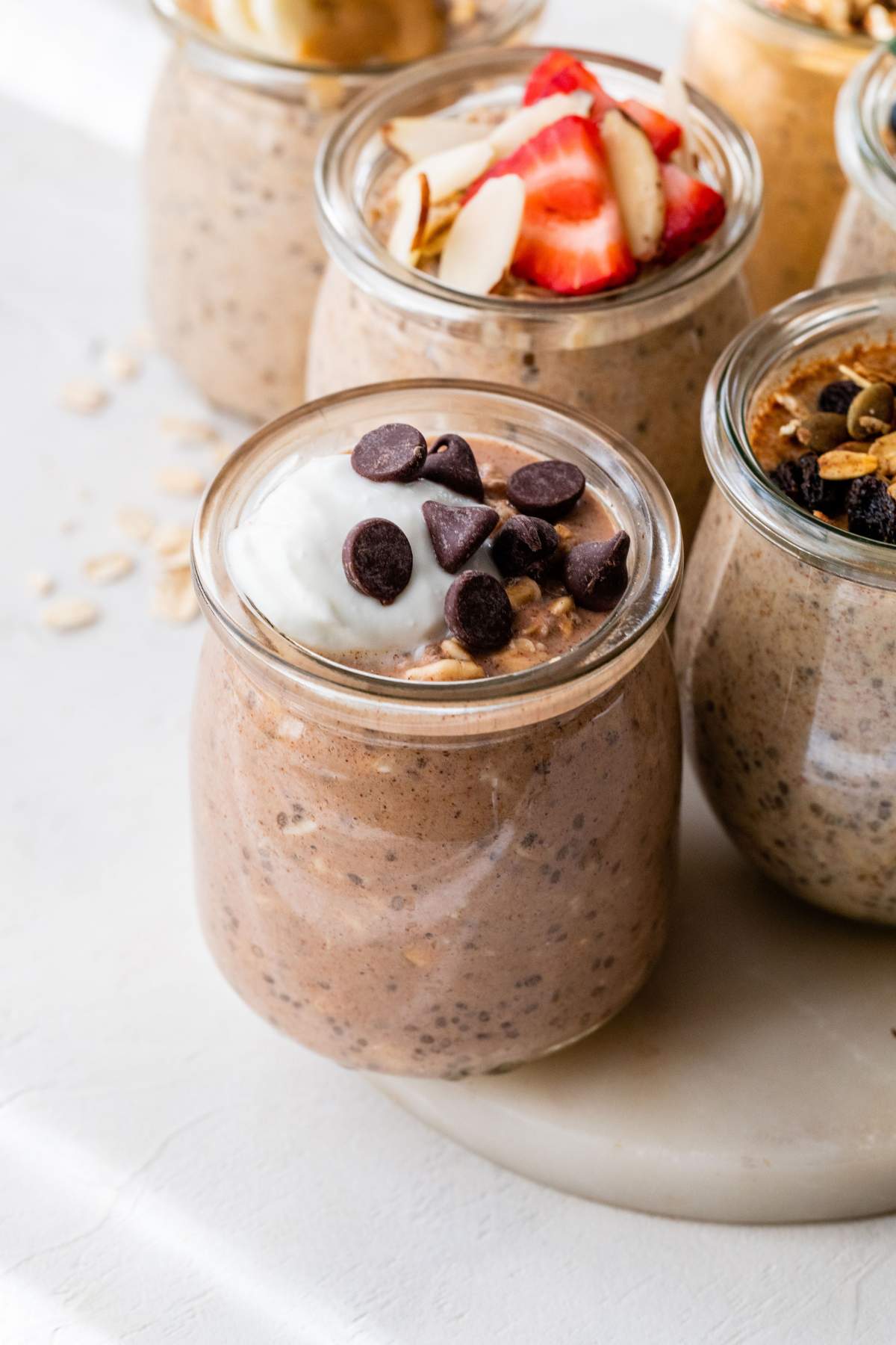 Small glass with overnight oats topped with a dollop of Greek yogurt and mini chocolate chips.
