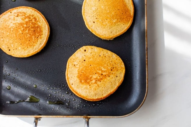 cooking pumpkin protein pancakes on a griddle