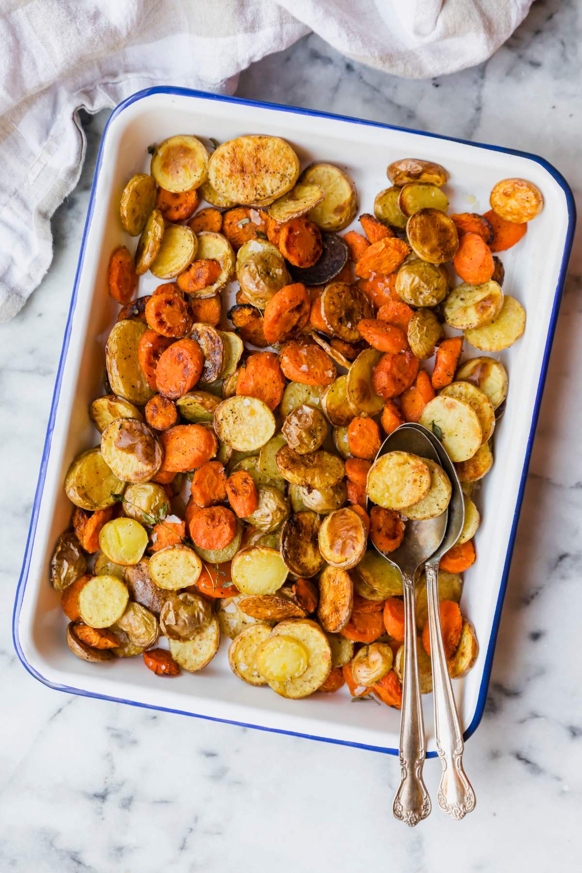 Roasted carrots and baby potatoes on a serving tray.