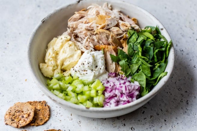chicken salad ingredients in a large white bowl