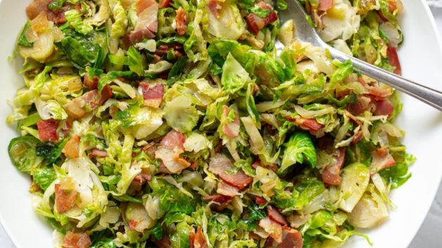 sautéed Brussels sprouts with pancetta in a white serving bowl