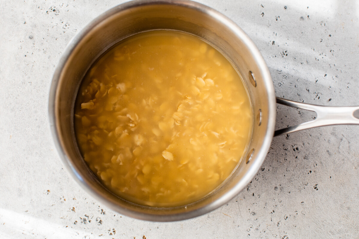 uncooked oats in a pot with broth before cooking