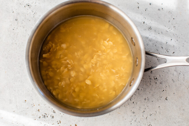 uncooked oats in a pot with broth before cooking