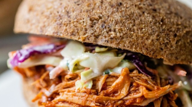 Shredded BBQ chicken and coleslaw on a bun.