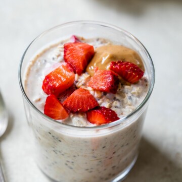 Glass jar with strawberry overnight oats topped with peanut butter.