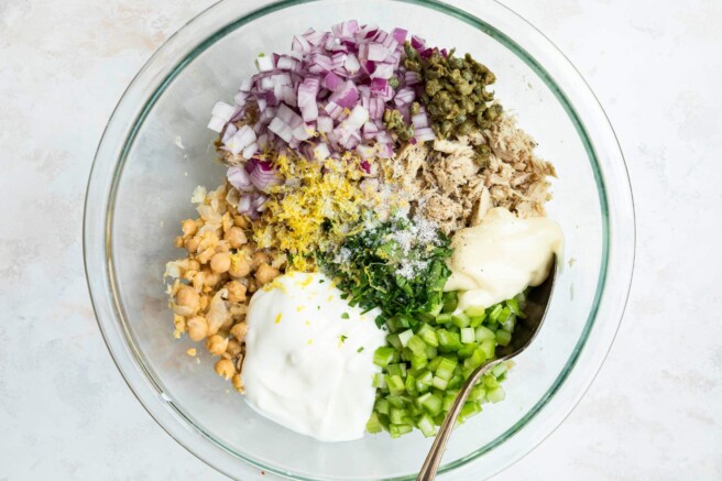 Tuna chickpea salad ingredients added to a large bowl.