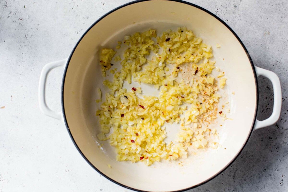 Sautéing onion and garlic in a large pot.