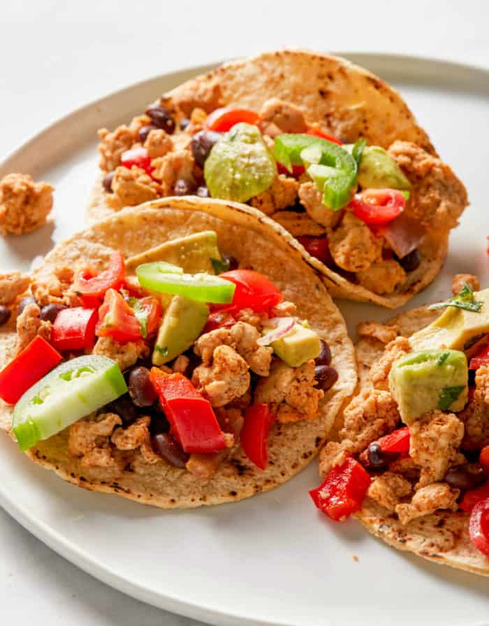 tacos made with ground turkey and black beans on a white plate