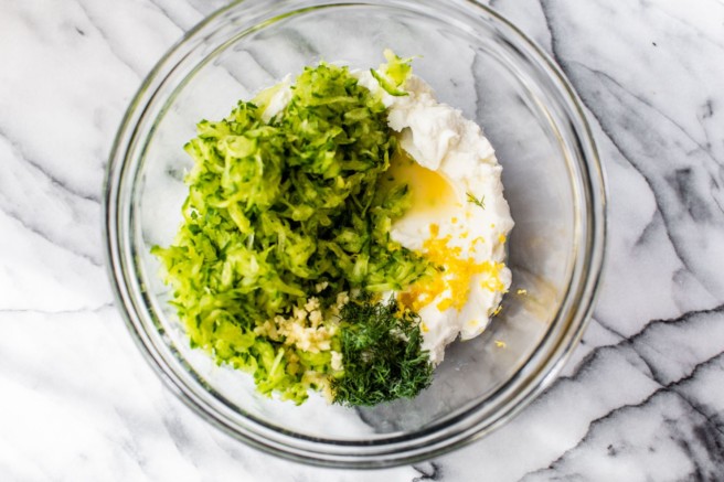 Combining ingredients for tzatziki in a large bowl.