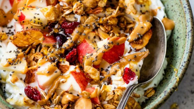Yogurt with granola, apple and topped with honey and chia seeds.