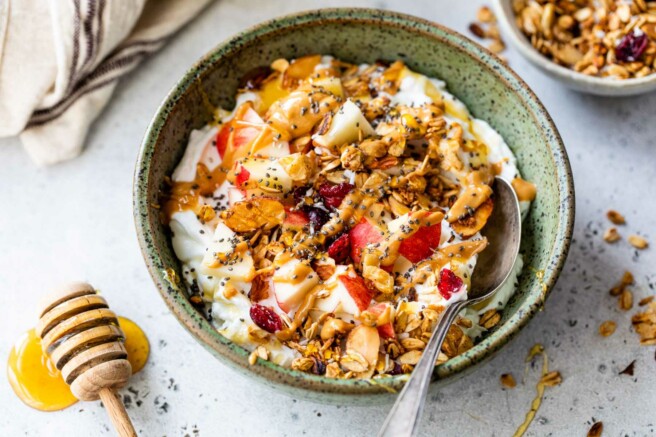 Yogurt with granola, apple and topped with honey and chia seeds.